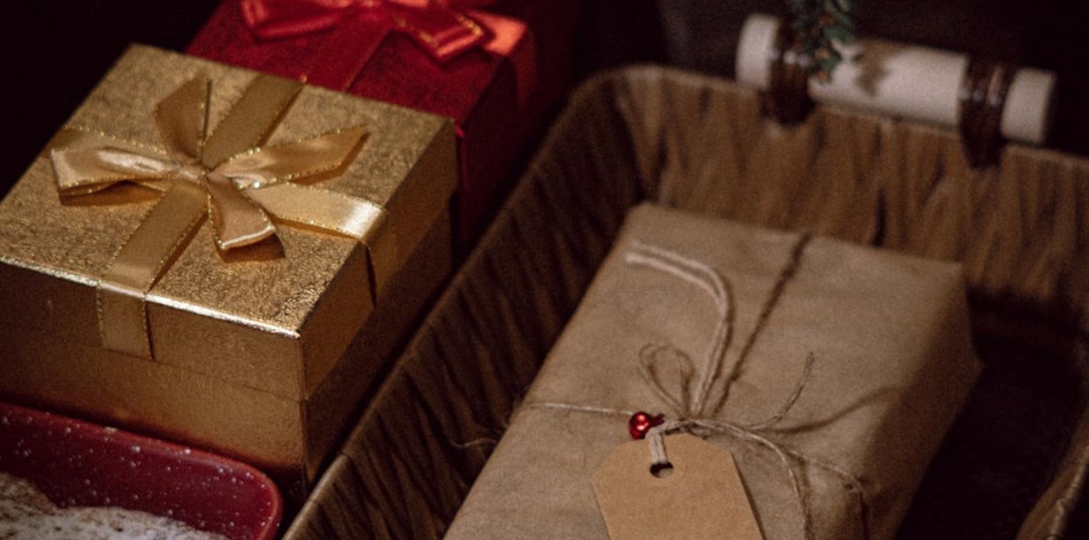 Regalos envueltos junto a un árbol de Navidad decorado