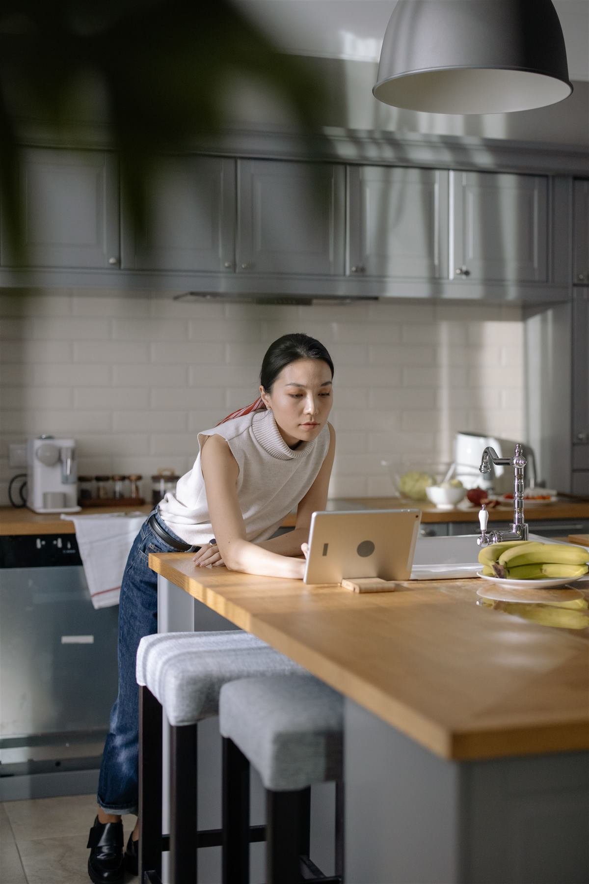 Mujer organizando tareas del hogar con una tablet en la cocina