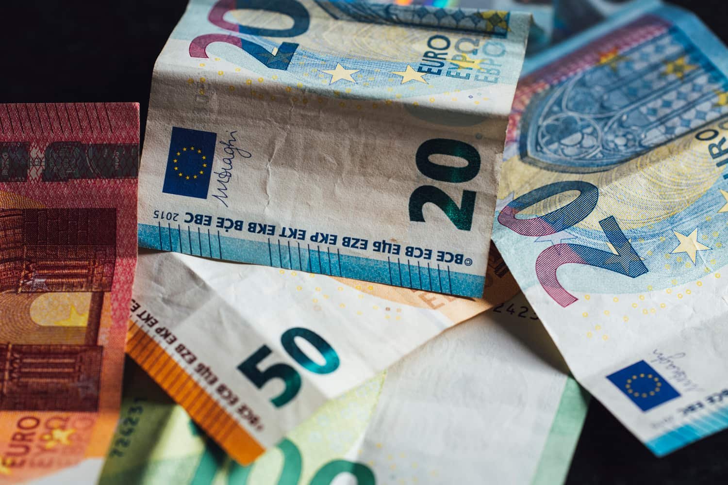 Billetes de 20 y 50 euros sobre una superficie oscura
