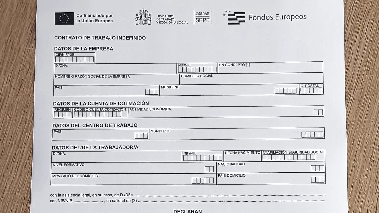 Modelo oficial de contrato de trabajo indefinido del SEPE impreso sobre una mesa de madera