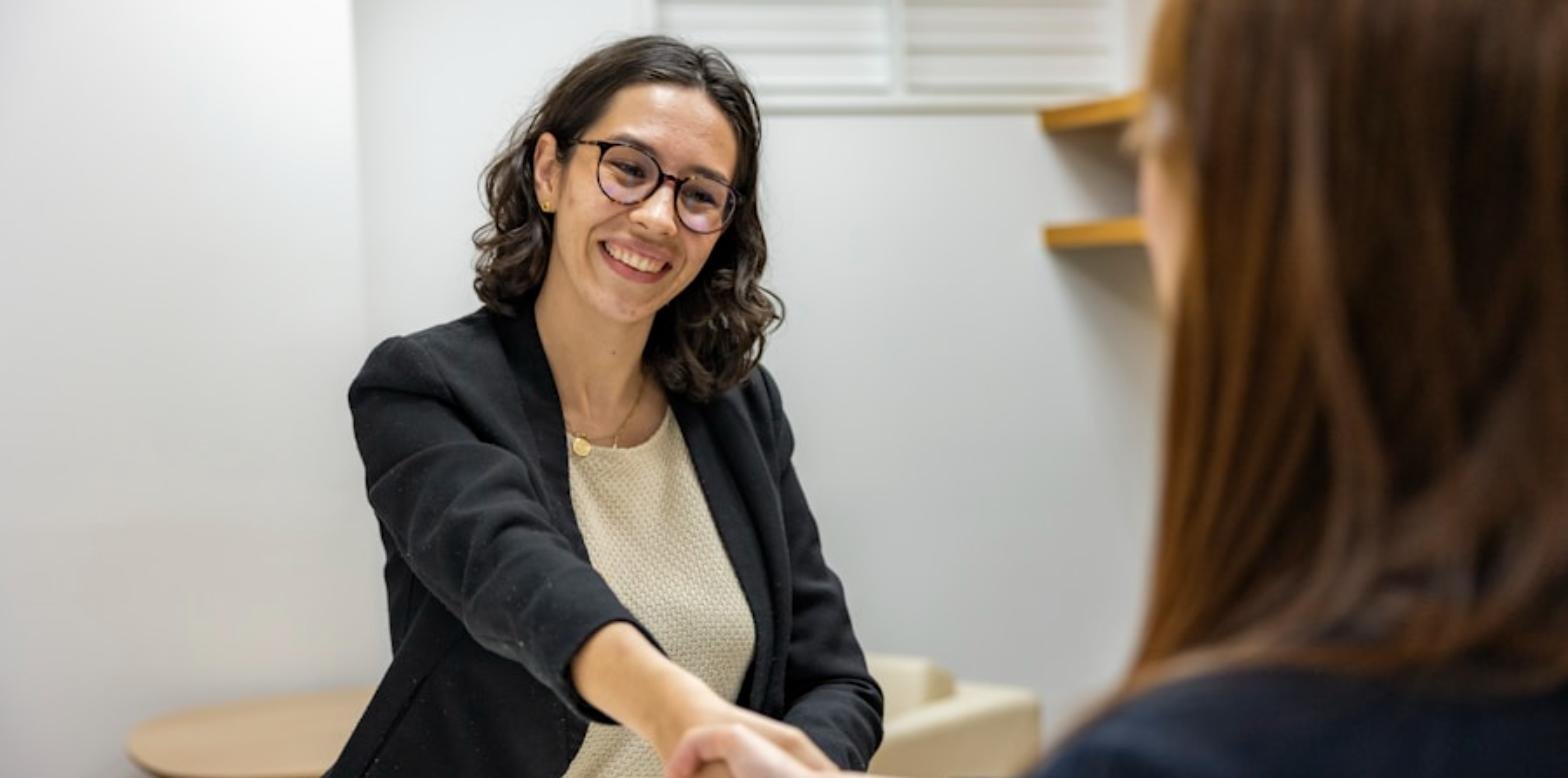 Una responsable de recursos humanos muestra un contrato a un candidato durante una entrevista de trabajo