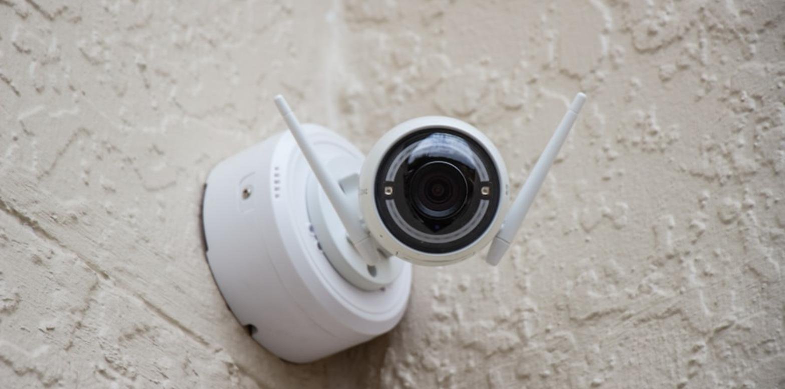 Cámara de videovigilancia blanca instalada en una pared